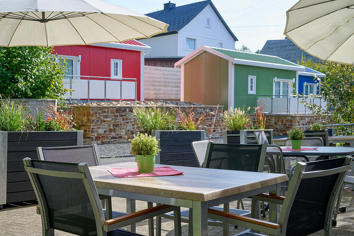 Terrasse mit Tischen und Stühlen für Senioren im Alloheim