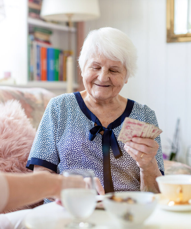 Bewohnerin spielt im Rahmen der Demenzbetreuung mit einer Pflegerin Karten in einer Alloheim Senioren-Residenz