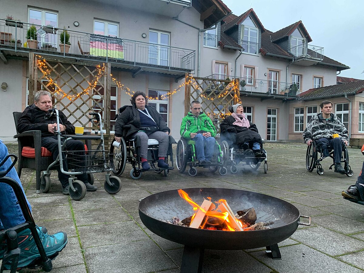 Bewohner sitzen an der Feuerschale