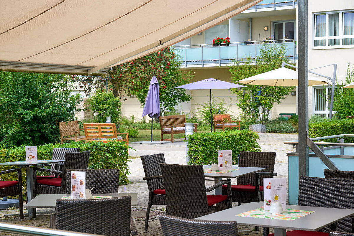 Terrasse mit Sonnenmarkise und Tischen und Stühlen