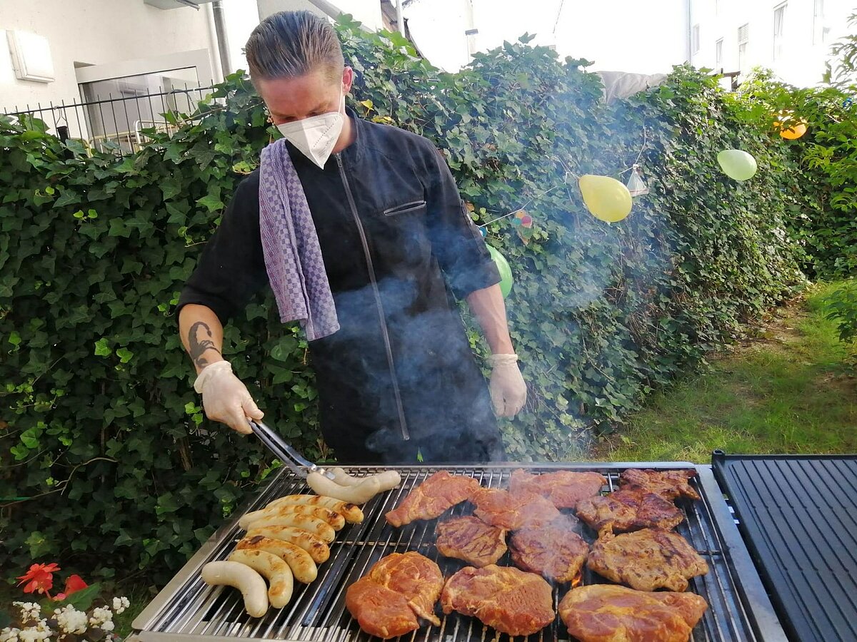 Mitarbeiter beim Grillen auf der Terrasse des Seniorenheims AGO Trier