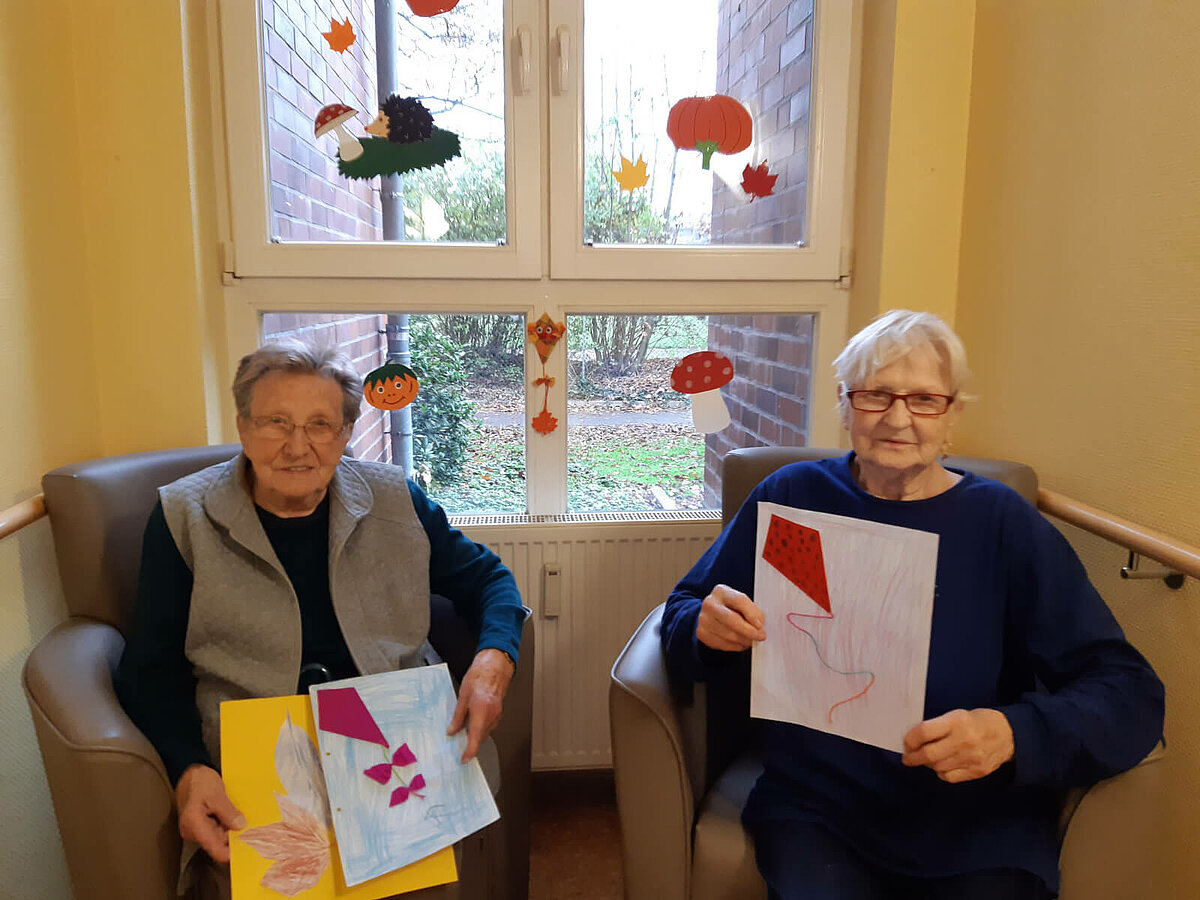 Seniorinnen mit gebastelten Herbstbildern aus der benachbarten Grundschule der Residenz "Am Lindenberg" in Salzgitter-Thiede