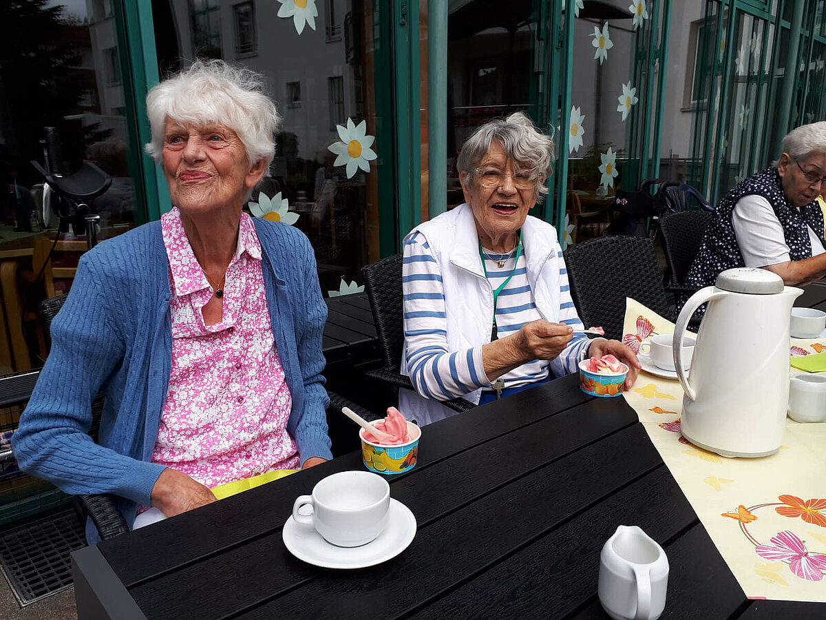 Seniorinnen essen Eis vor der Senioren-Residenz "Waldersee" in Lübeck