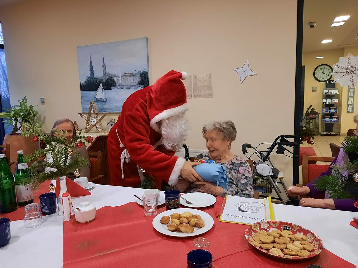 Weihnachtsmann beschenkt Seniorin