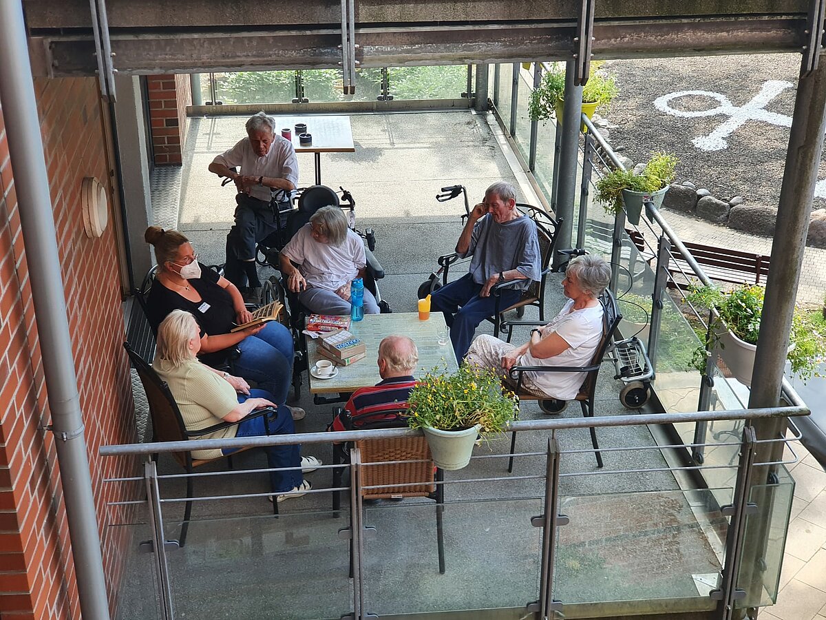 Leserunde auf dem Balkon im Seniorenzentrum Kapernaum in Hamburg