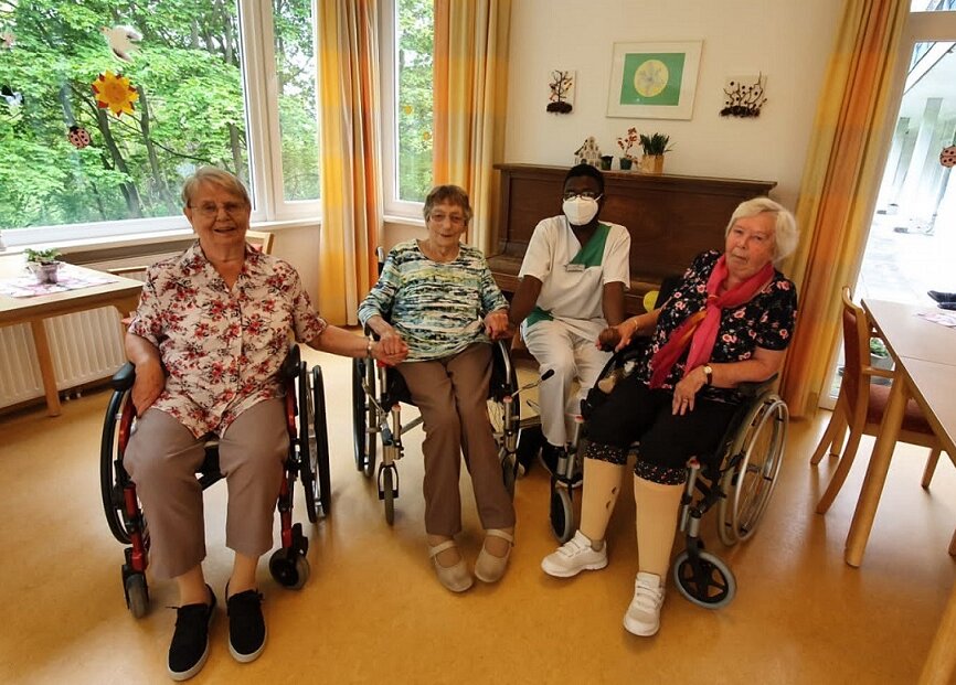 Pflegehelfer Archippe Ombang mit Seniorinnen des Seniorenzentrums Kiel-Pries