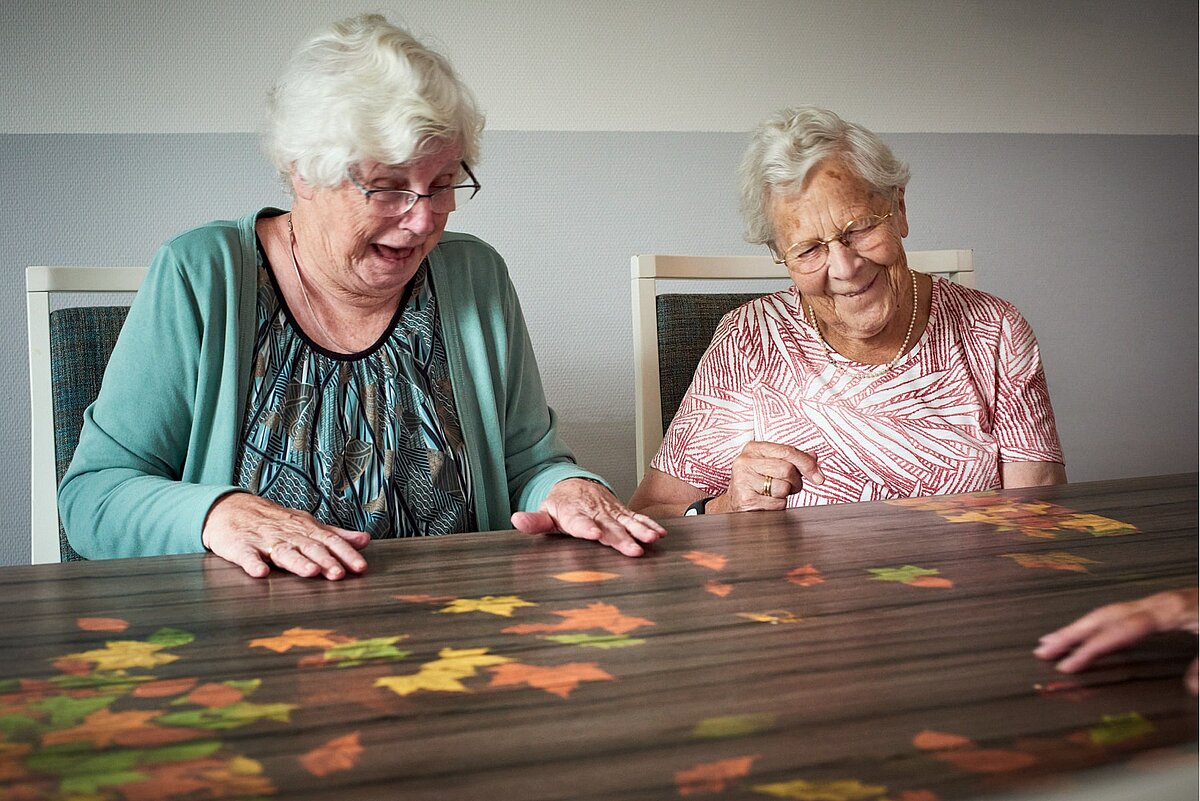 Seniorinnen spielen mit digitalen Blättern durch die Tovertafel