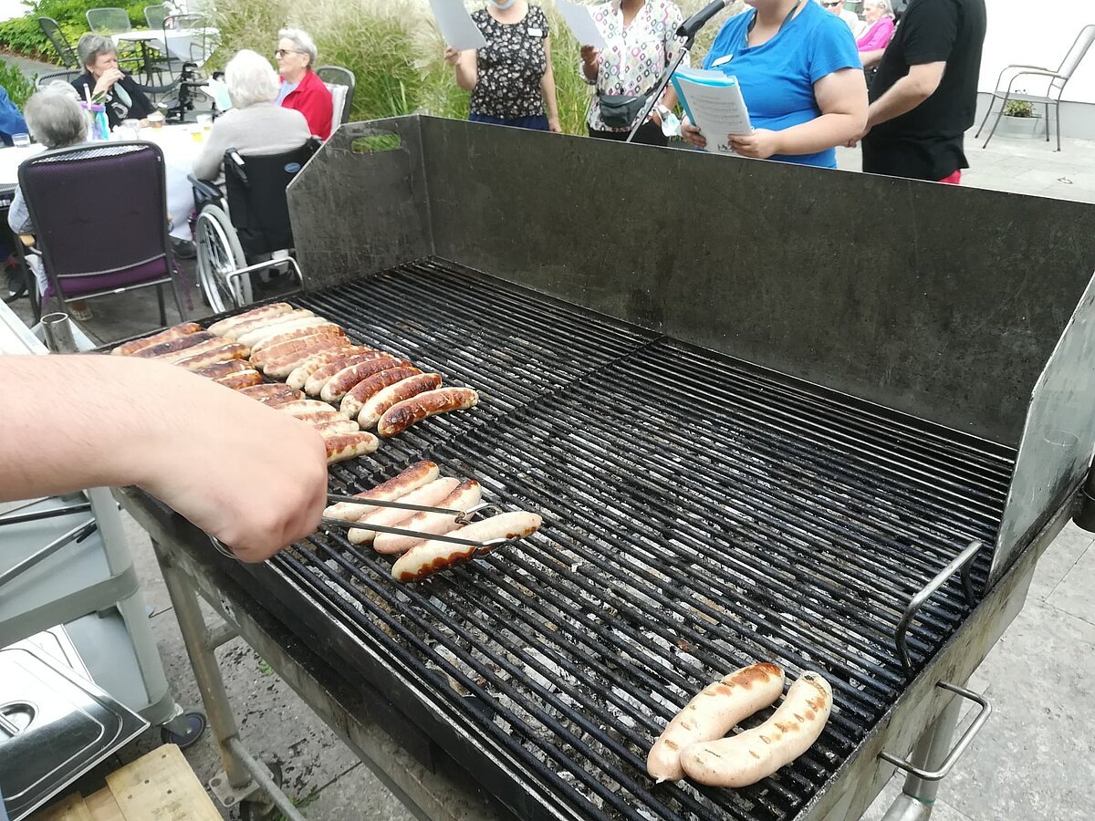 Würstchen beim Grillfest im Innenhof der Alloheim Senioren-Residenz "Am Hirschgarten" in Erfurt 