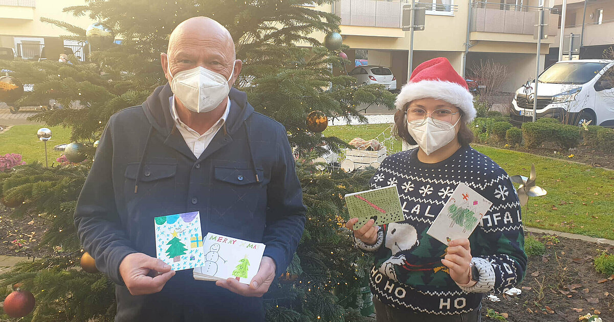 Residenzleiter und Mitarbeiterin des Pflegeheim "Haus am Stadtpark" in Schwerte verteilen Postkarten