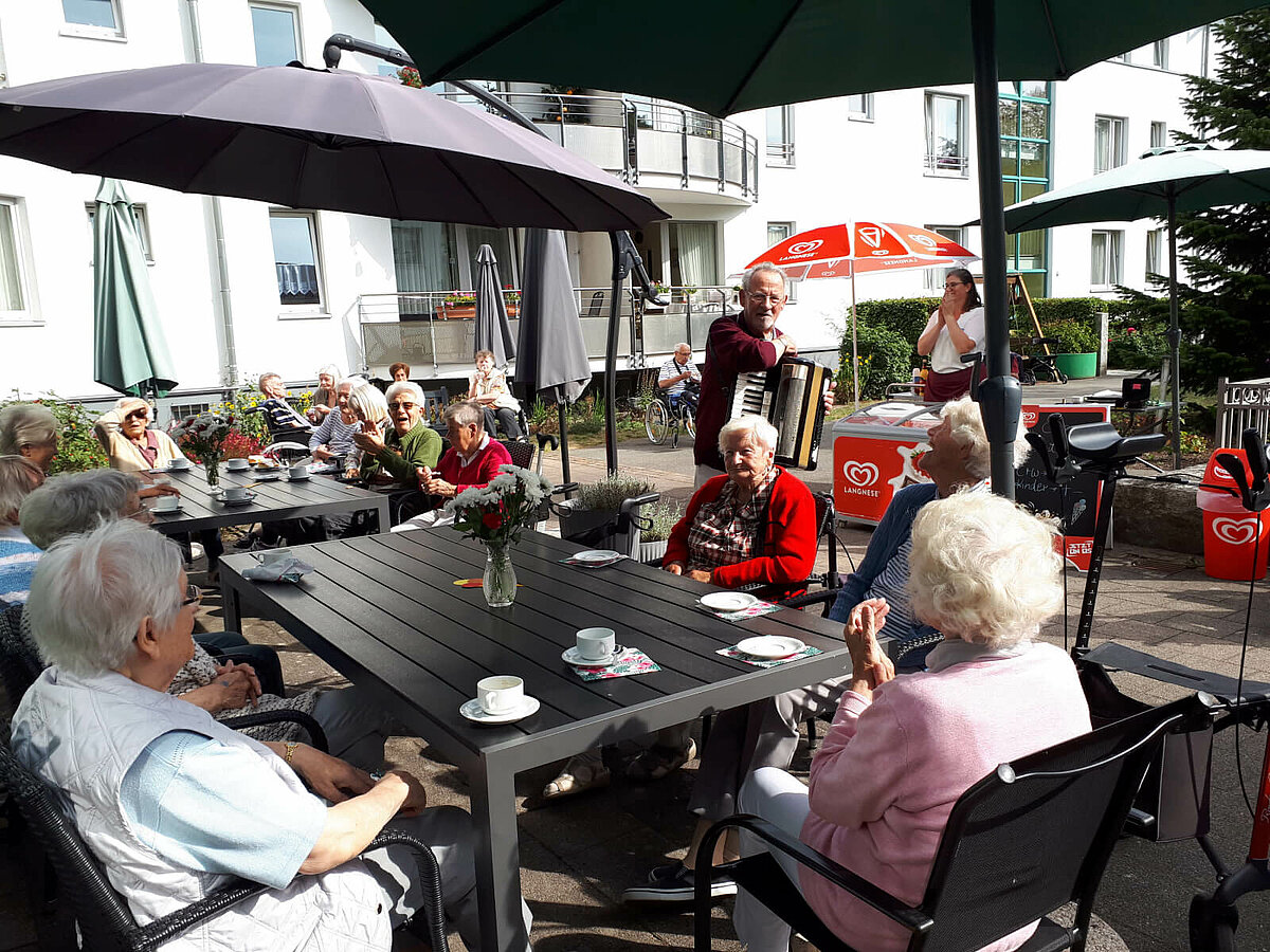 Senioren essen Eis auf Terrasse des Pflegeheims "Waldersee" in Lübeck