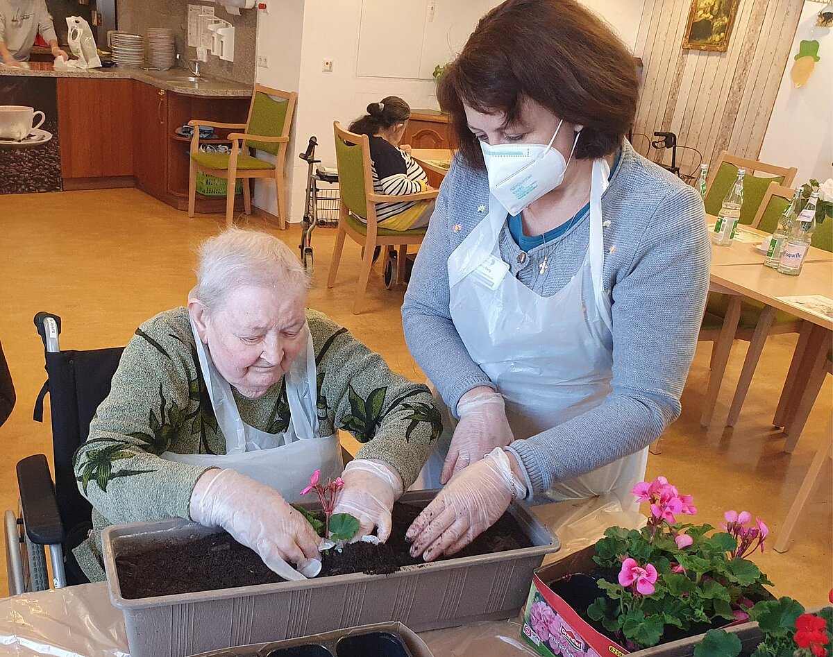 Bewohnerin und Mitarbeiterin des Sozialen Diensts bei der Balkonbepflanzung im Seniorenzentrum "Im Kaiserviertel" in Dortmund
