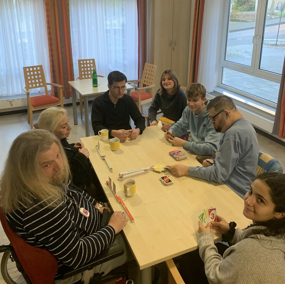 Gruppe sitzt am Tisch und spielt