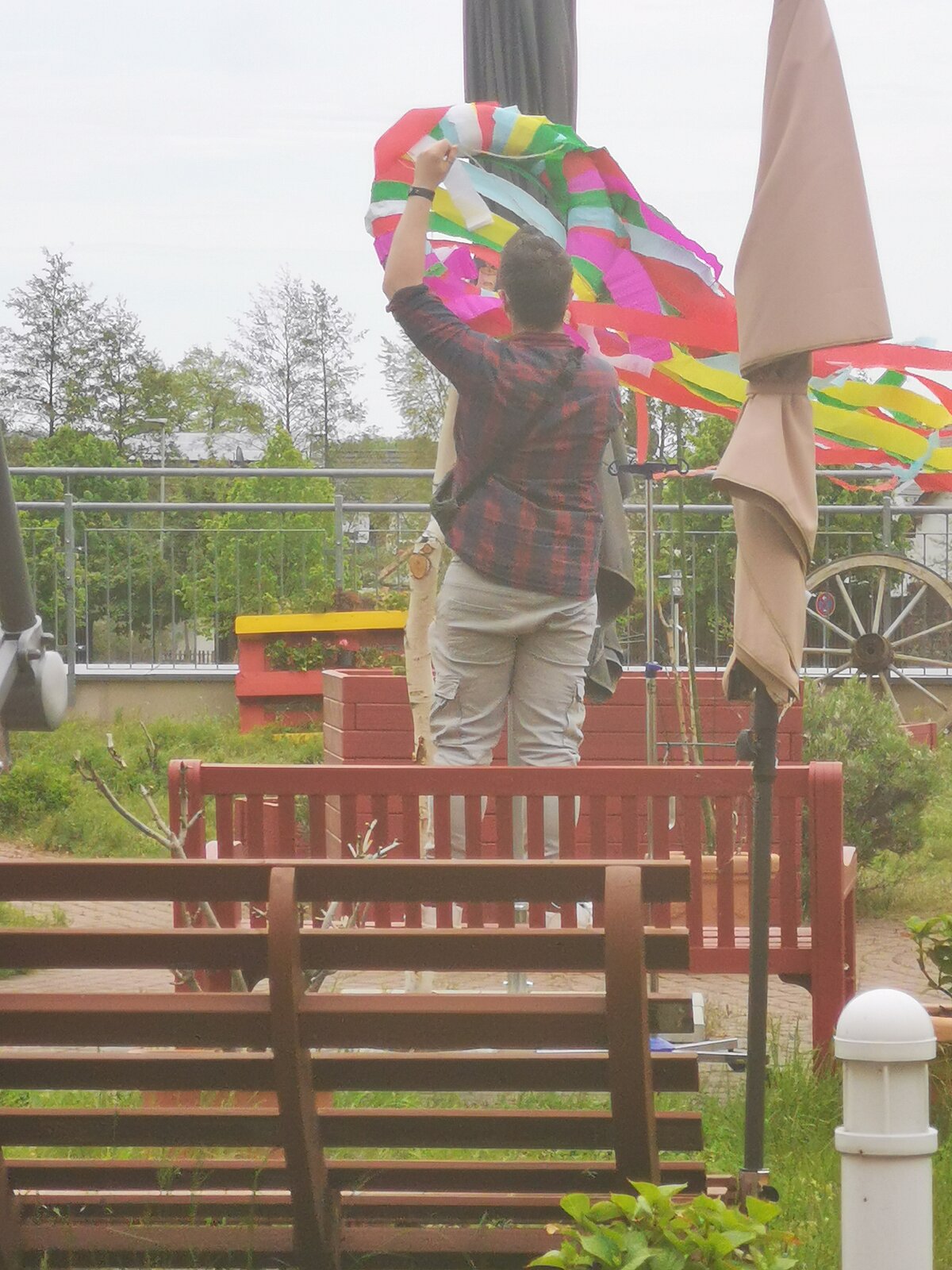 Maibaum wir mit buntem Kranz geschmückt im Demenzgarten des Seniorenzentrum AGO Rosbach