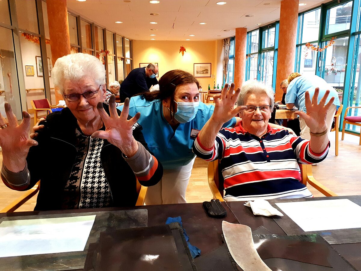 Seniorinnen haben schwarze Finger nach dem Malkurs in der Senioren-Residenz "Waldersee" in Lübeck