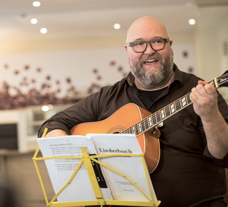 Kai von Lünenschloß spielt Gitarre in der Musiktherapiegruppe der Alloheim-Seniorenresidenz Wuppertal
