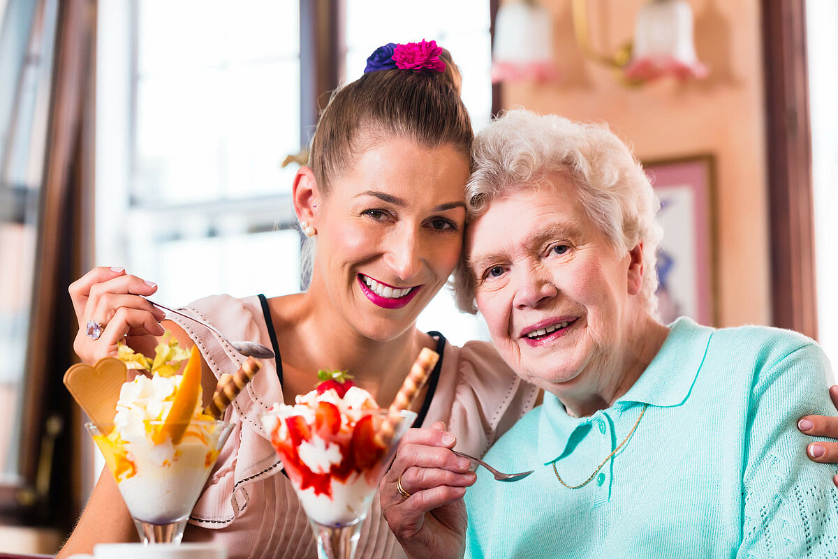 Junge Frau mit Seniorin beim Eis essen