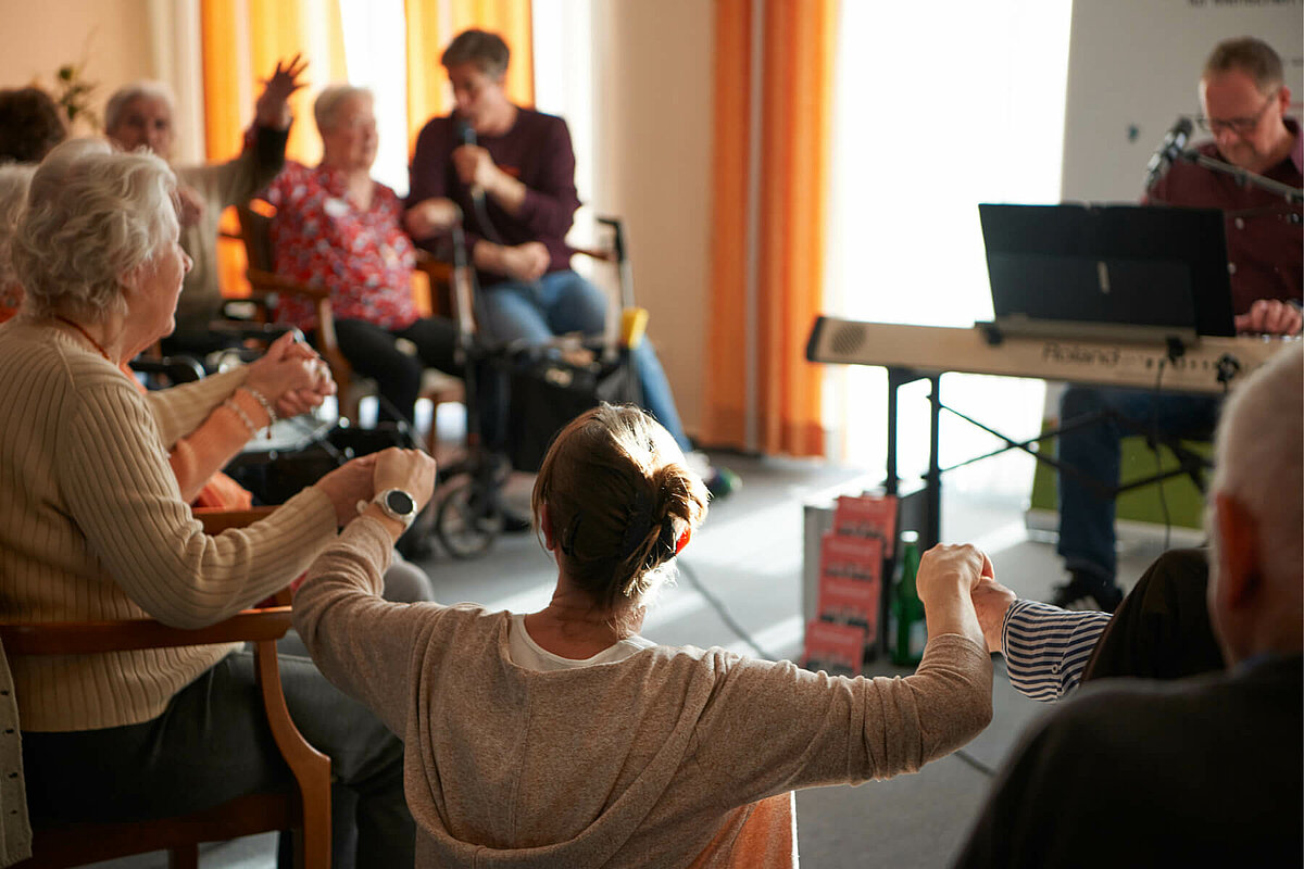 Bewohner schunkeln zusammen bei einem Konzert im CMS Pflegewohnstift Pattensen