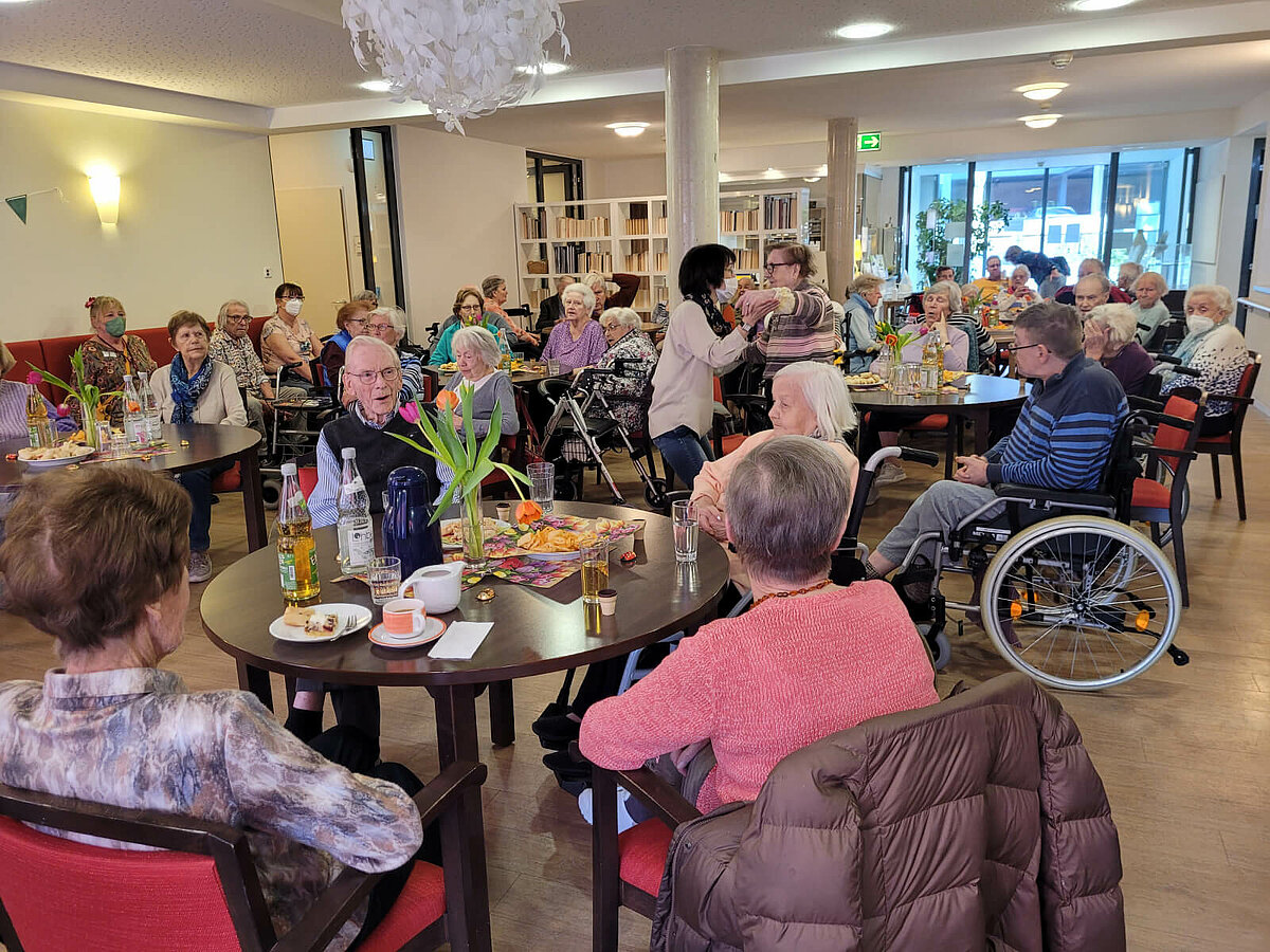 Bewohner sitzen zusammen beim Frühlingsfest im Seniorenheim in Warendorf