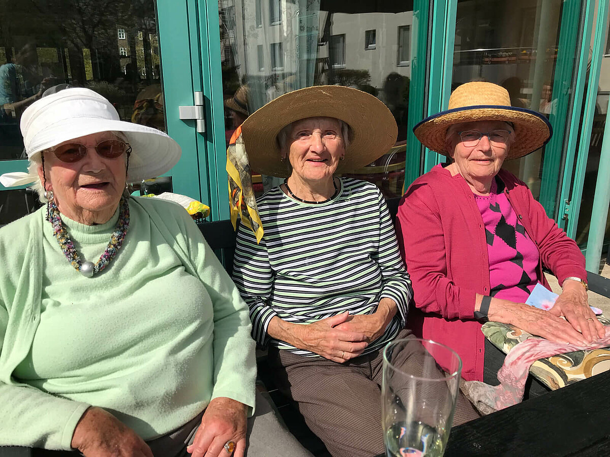 Seniorinnen mit Sonnenhüten beim Maifest des Seniorenheims Lübeck