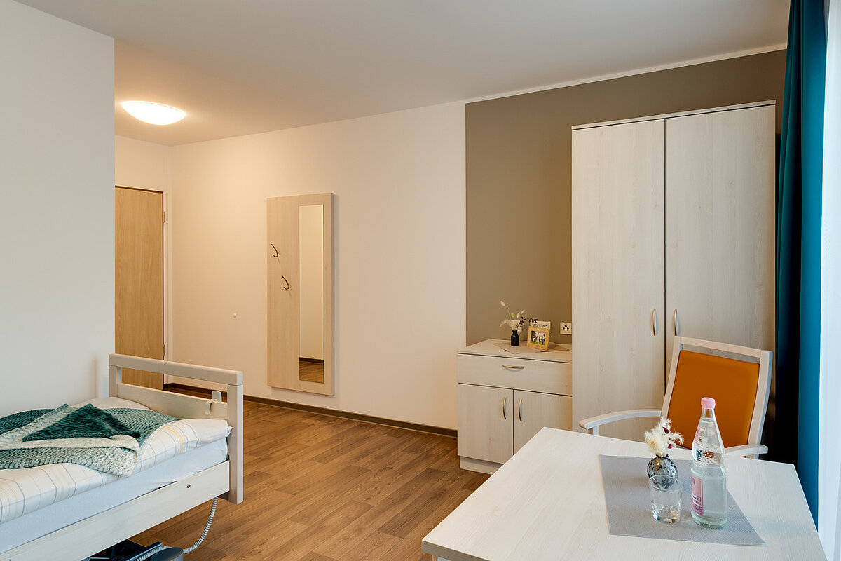 Einzelzimmer mit Schrank und Sitzecke