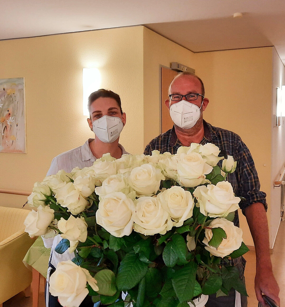 Mitarbeiter mit weißen Rosen zum Weltfrauentag in der Residenz Aaseehof