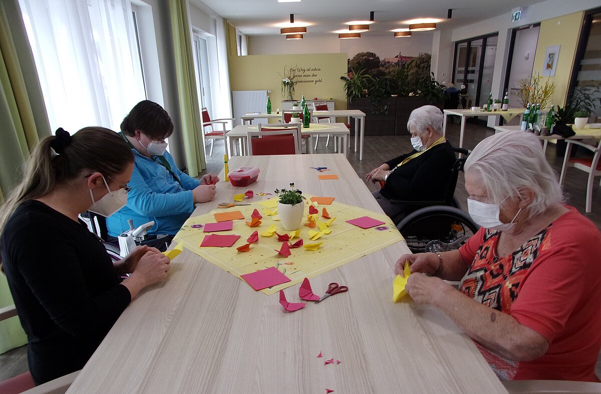 Bewohner der Alloheim Senioren-Residenz "Am Sieberdamm" in Herzberg basteln zusammen Schmetterlinge