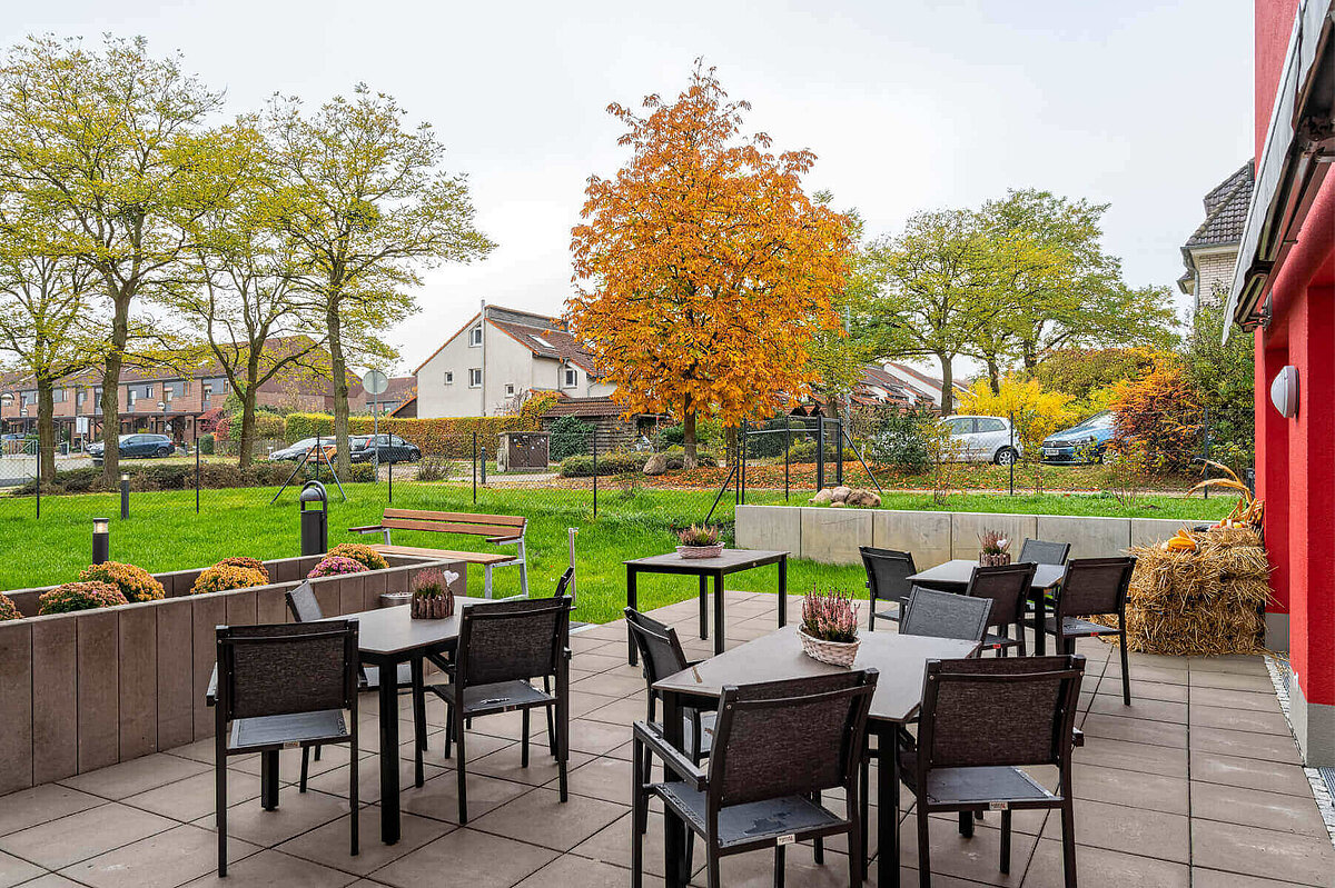 Terrasse mit Tischen und Stühlen hinter dem Seniorenheim "Am Nemerower Holz" in Neubrandenburg