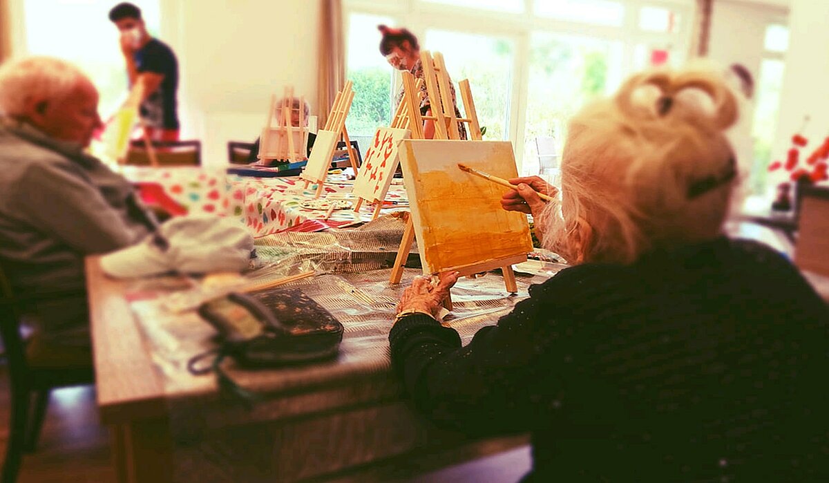 Senioren malen Bilder auf Leinwand in einer Alloheim Senioren-Residenz