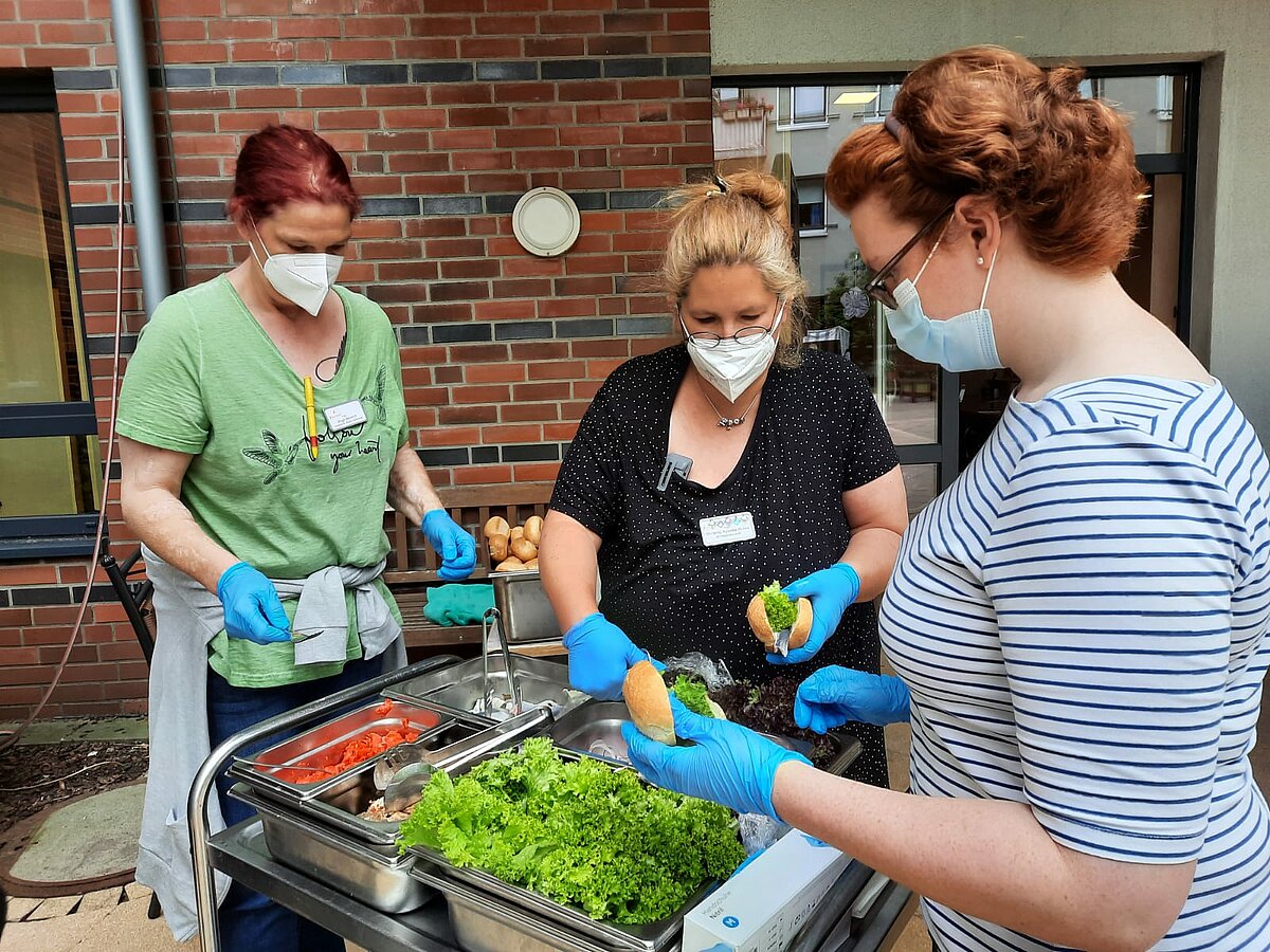 Mitarbeiter des sozialen Diensts belegen Fischbrötchen für die Bewohner des Seniorenzentrums Kapernaum in Hamburg