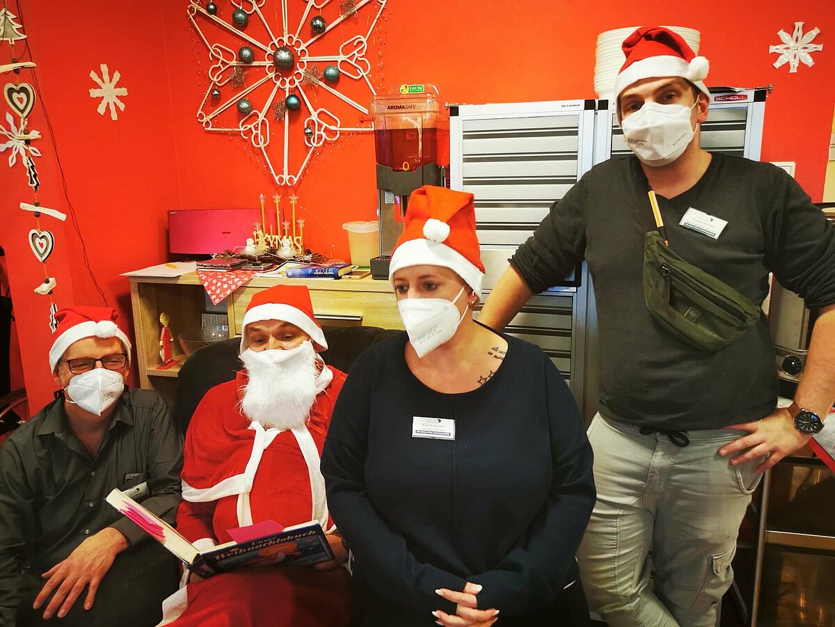 Mitarbeiter als Nikolaus verkleidet liest für die Bewohner des Seniorenzentrums AGO Rosbach vor