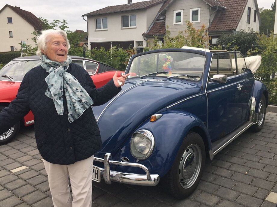 Bewohnerin an einem Oldtimer bei der Alloheim Senioren-Residenz "Am Sieberdamm"