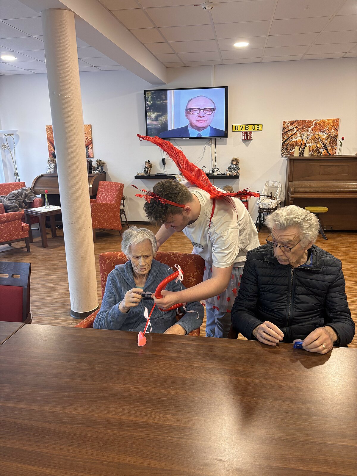 Mitarbeiter verteilt verkleidet Geschenke zum Valentinstag