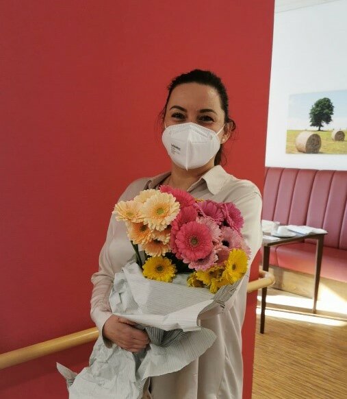 Mitarbeiterin des Seniorenhaus "Kurler Busch" in Dortmund mit Blumen