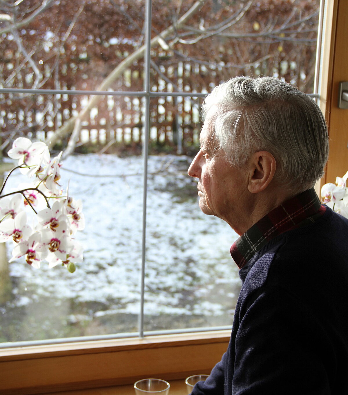 Einsamer Senior schaut aus dem Fenster