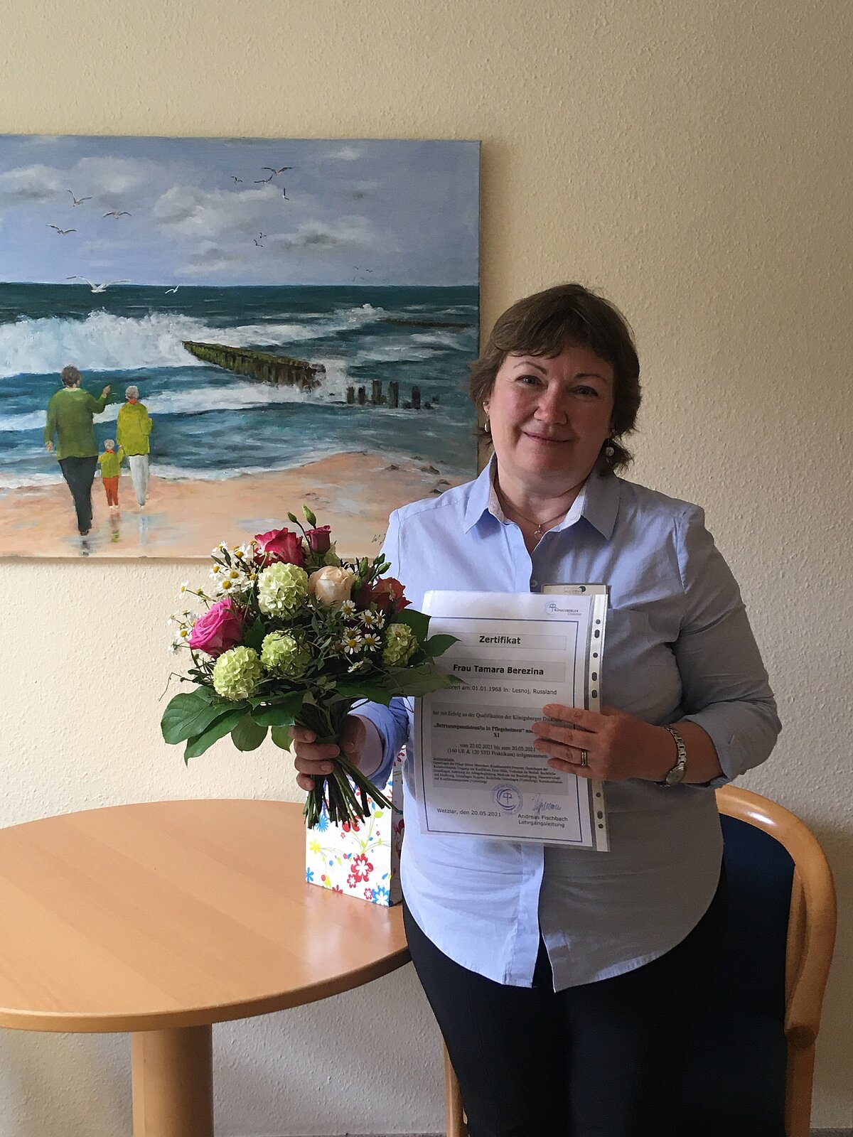 Tamara Berezina mit Blumenstrauß für die Weiterbildung zur Betreuungsassistentin