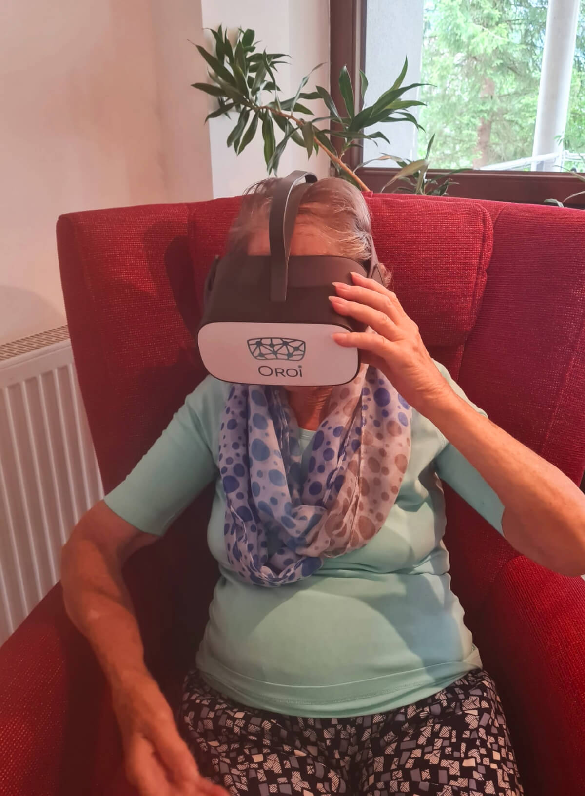 Seniorin im Pflegeheim trägt VR-Brille von Oroi