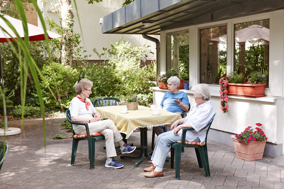 Seniorinnen sitzen zusammen auf Terrasse vor dem Betreuten Wohnen in Berlin Lichterfelde - Heerstraße