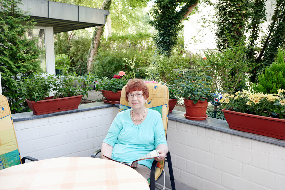 Seniorin sitzt auf Terrasse vor ihrer Wohnung im Alloheim Betreuten Wohnen in Berlin Lichterfelde - Heerstraße