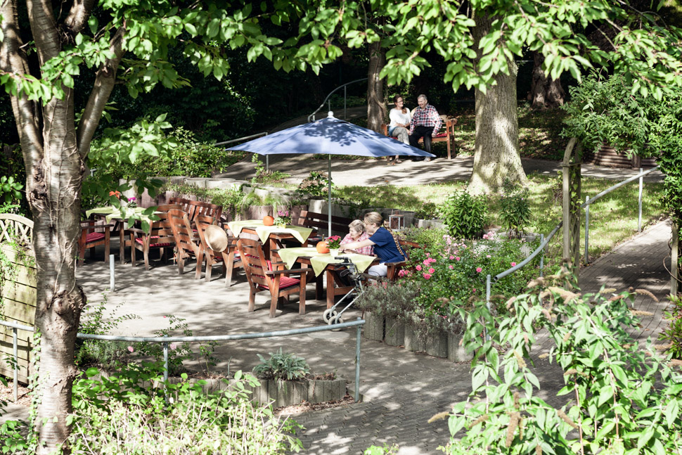 Bewohner sitzen gemütlich auf der Terrasse des Alloheim Pflegeheims Godenbergschlößchen in Bad Malente