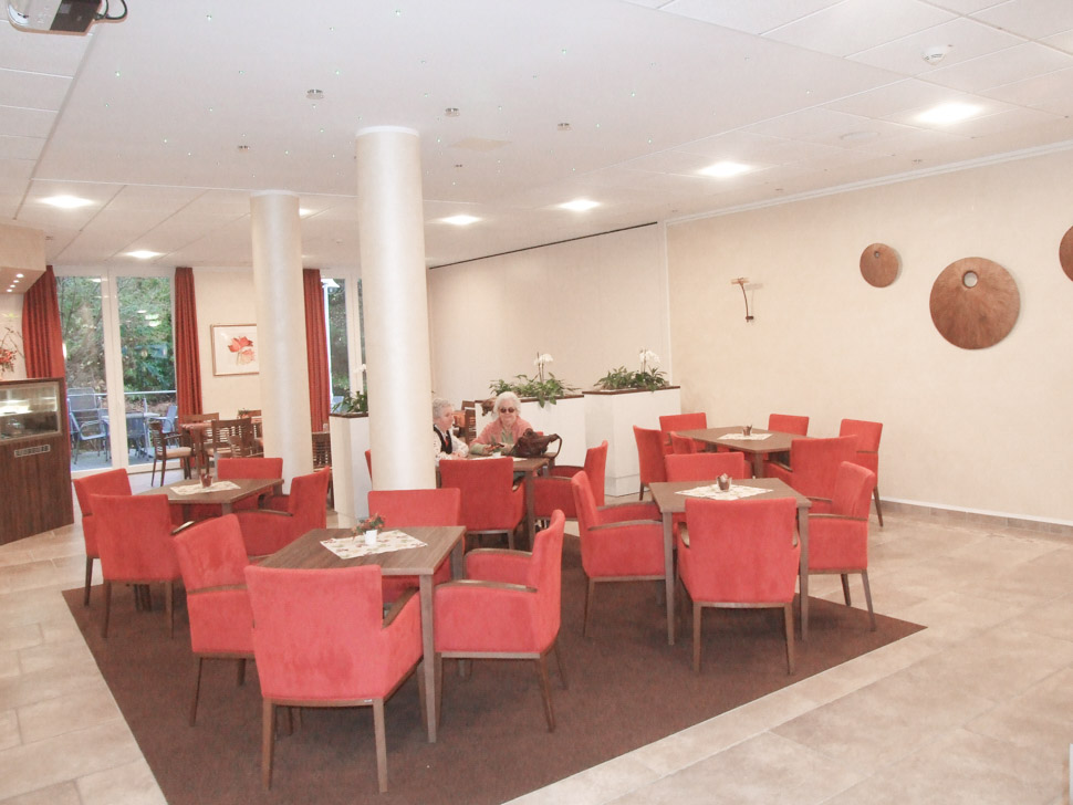 Gemeinschaftsraum mit roten Sesseln im Alloheim Pflegeheim Anna Margareta in Bad Malente