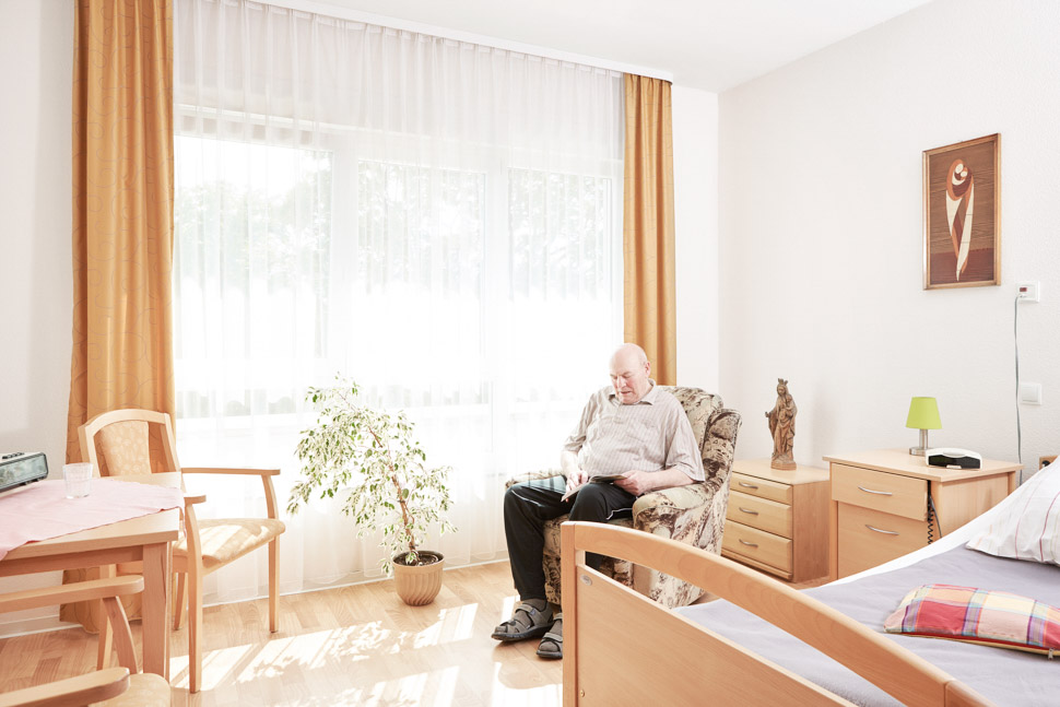Bewohner sitzt in Sessel in seinem Zimmer des Alloheim Altenheims Löwenquell in Bad Rodach