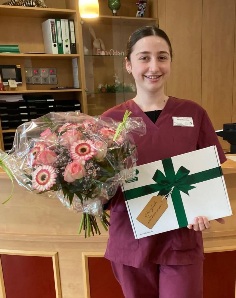 Mitarbeiterin hat ihren Abschluss gemacht und bekommt Blumen 