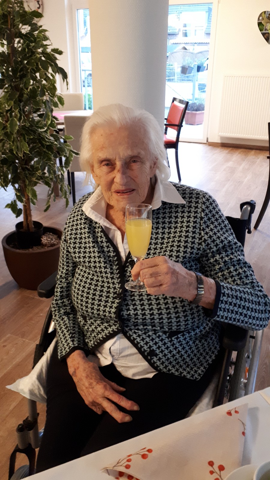 Bewohnerin beim Sekt trinken 
