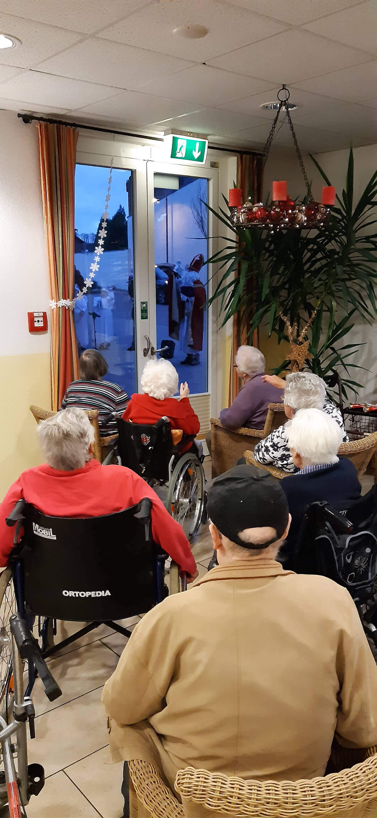 Bewohner der Alloheim Senioren-Residenz Elsdorf hören dem Nikolauskonzert vor dem Fenster zu