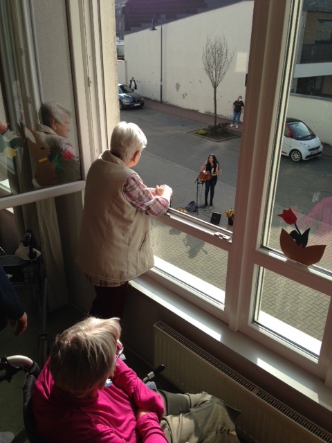 Bewohner der Alloheim Senioren-Residenz Elsdorf schauen dem Osterkonzert aus dem Fenster zu