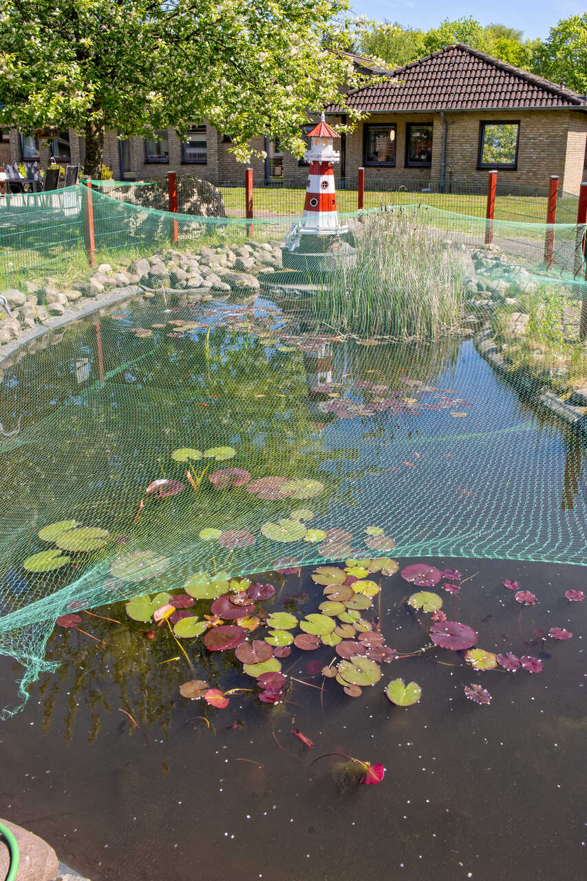 Teich und kleiner Leuchtturm im Garten