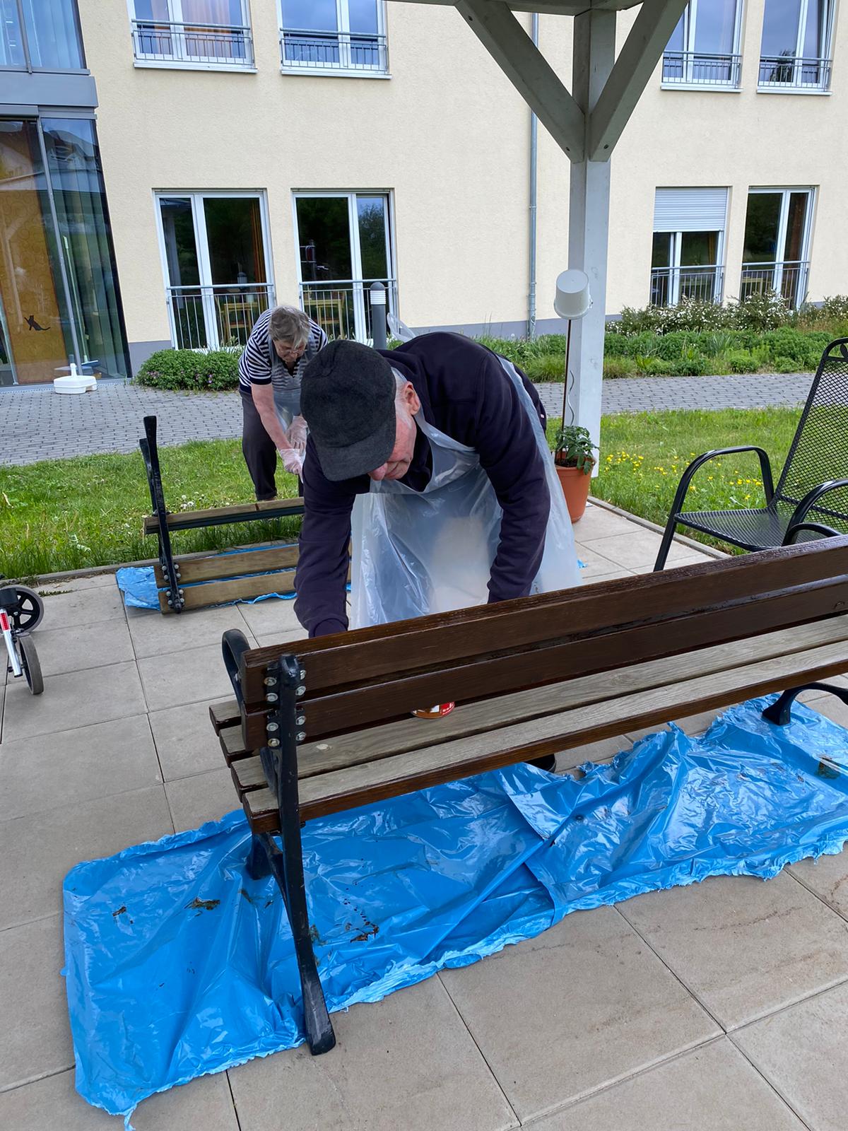 Bewohner des Pflegeheim Mainbrücke in Marktheidenfeld streichen Holzbänke