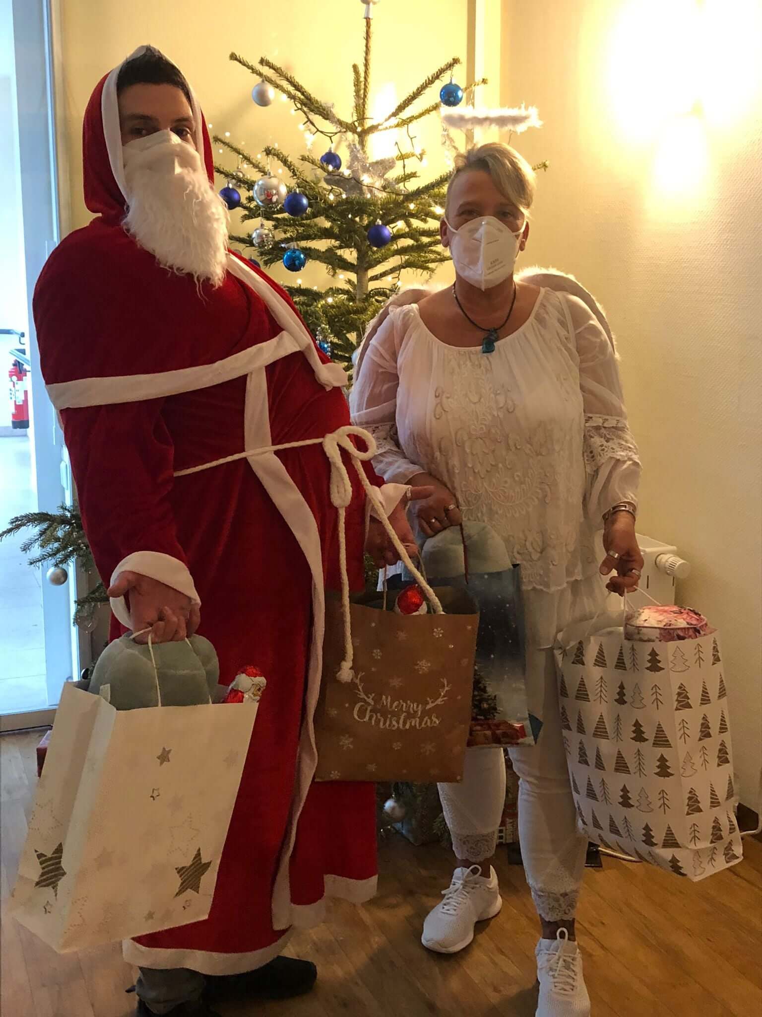 Als Nikolaus und Engel verkleidete Mitarbeiter verteilen Geschenke an die Bewohner des Seniorenheims "AGO Rosbach"