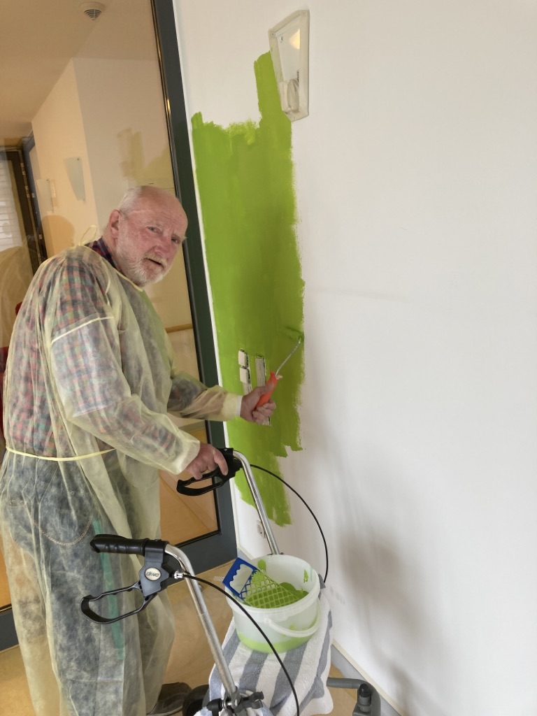 Bewohner streicht die Wand des Wintergartens im Pflegezentrum Sundern
