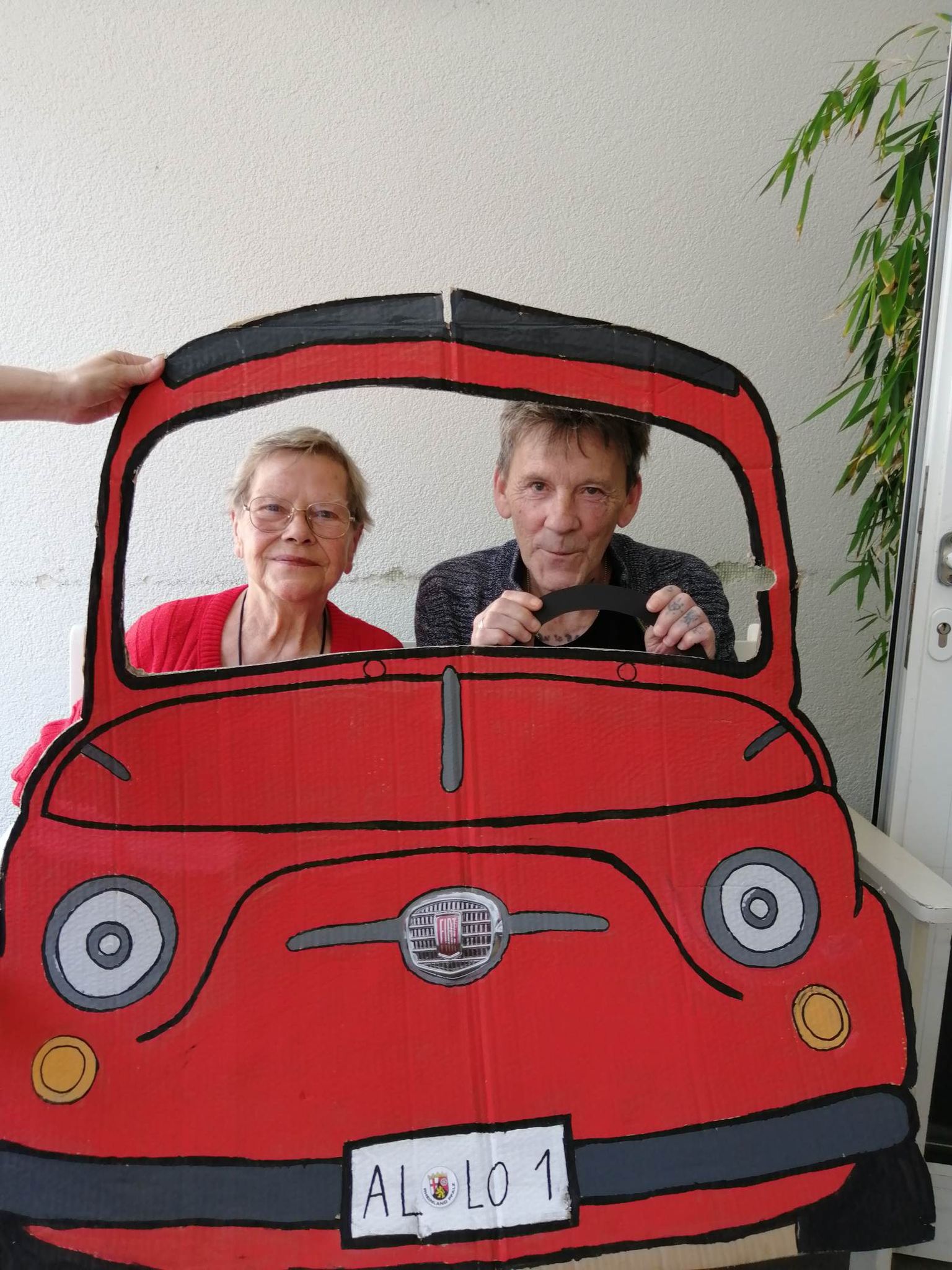 Bewohner hinter Papp-Auto bei der italienischen Woche - Rom im Seniorenzentrum AGO Trier 